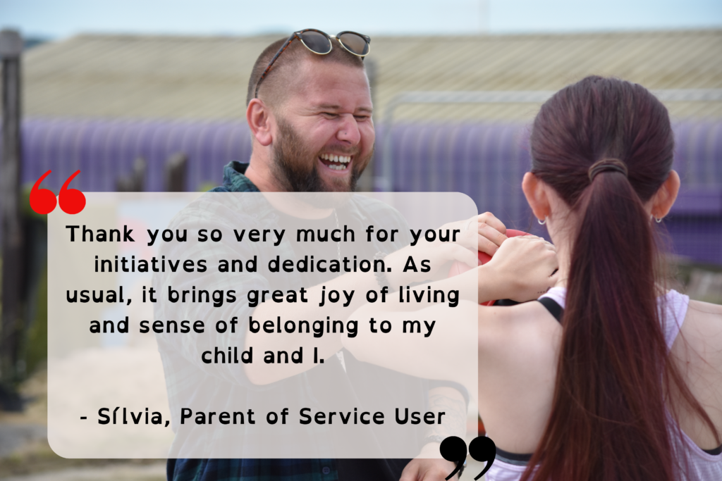 A photo of a parent and child grinning whilst boxing at the Eastbourne Festival of Accessible Sport in 2023. Layered on top of the image is the following text "Thank you so very much for your initiatives and dedication. As usual, it brings great joy of living and sense of belonging to my child and I. - Sílvia, Parent of Service User"